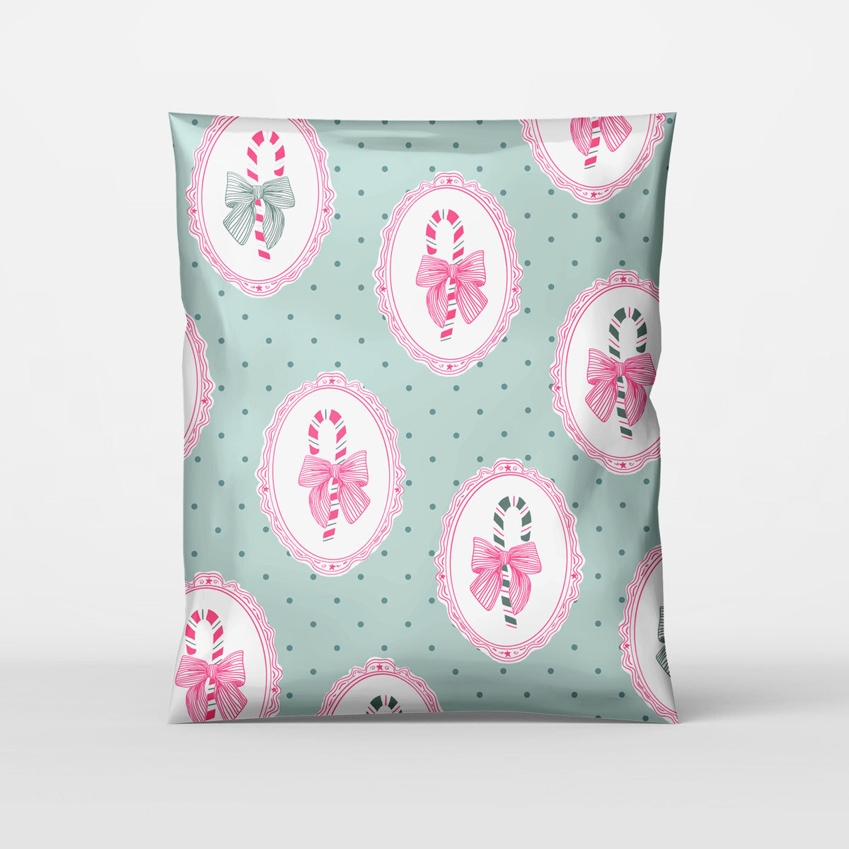 cute christmas polymailer with mint green background, forest green polka dots, and hot pink frames with hand drawn candy canes with bows inside. Cute trending design pattern for small business holiday shipping.