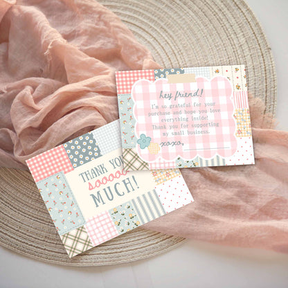 Two customer thank you message thank-you cards front and back with a patchwork design in pastel pink, blue, green, and yellow, styled on a woven placemat with draped pink fabric.  Front says thank you sooooo much!  Back has a thank you for supporting my small business message.
